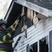 A firefighter make holes in the burned mobile home. Daniel Brenner I AnnArbor.com